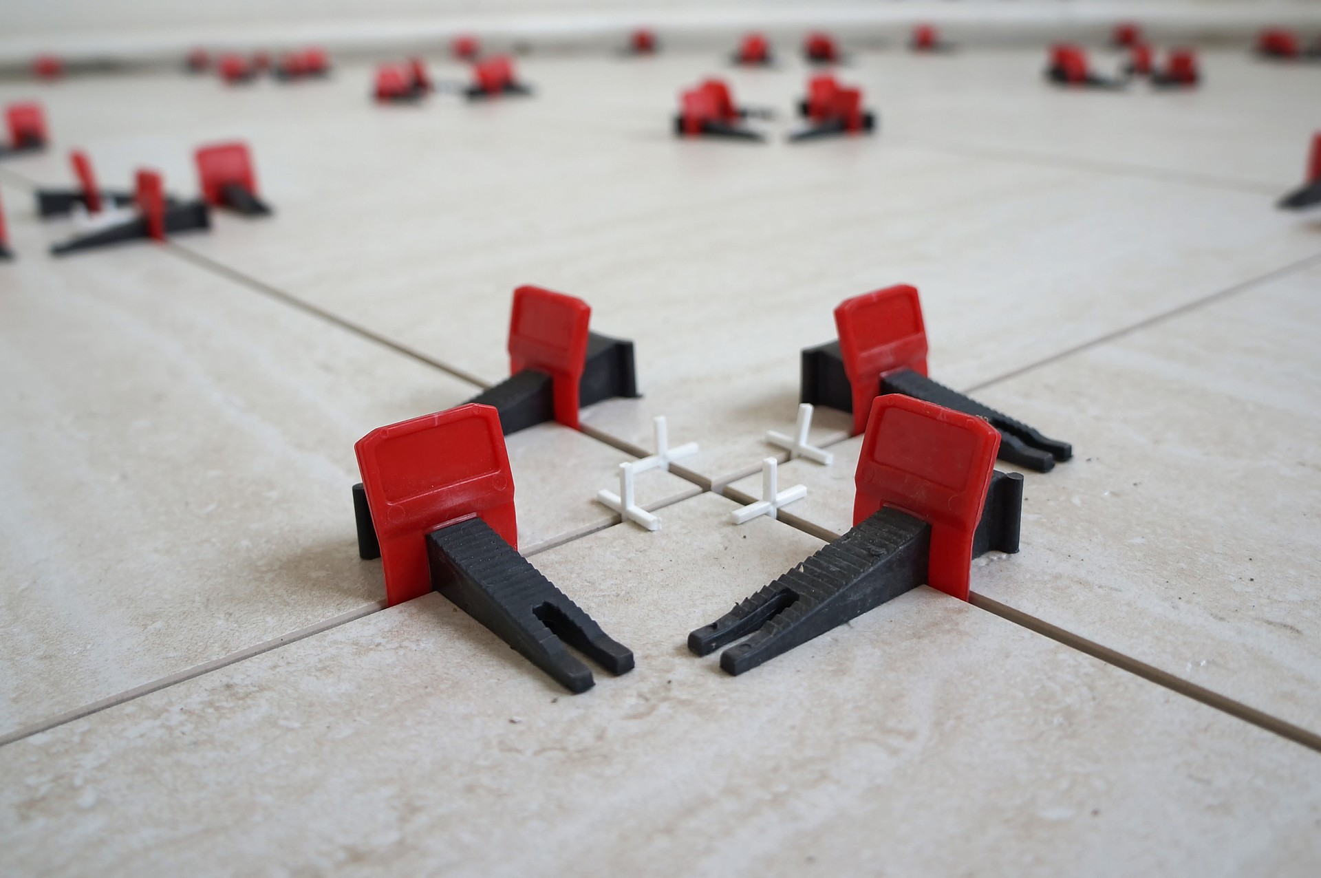 Tile levelling system with plastic clips and wedges. Close-up view